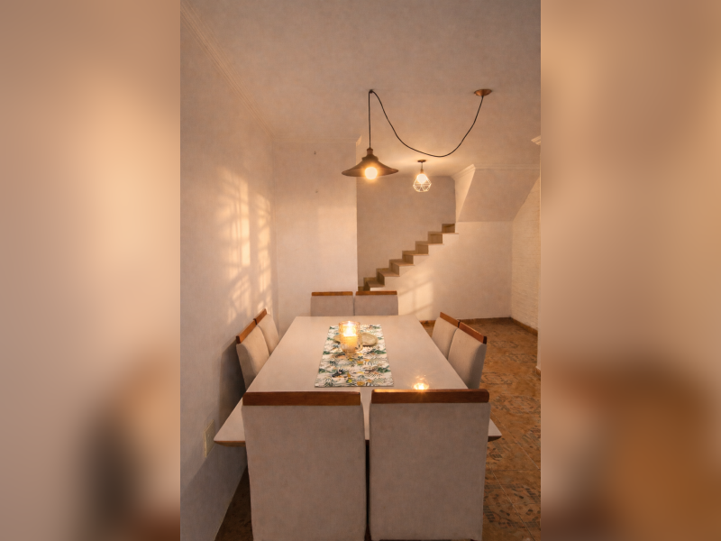 Casa à venda Jardim Sílvia com 173m² e 3 quartos por R$ 397.000 - sobrado-aconchegante-embu-das-artes-sala-de-jantar-espacosa-com-iluminacao-aconchegante-lustre-pendente-e-acesso-para-escada.png